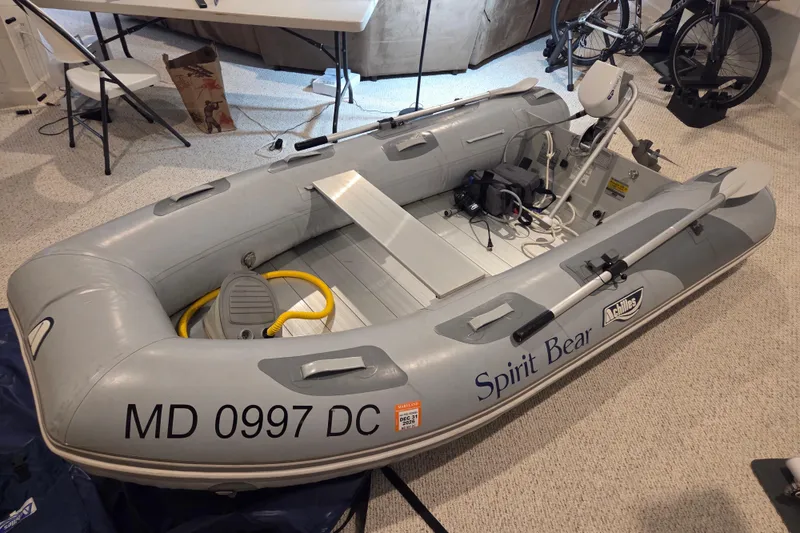 Slide: The Image of Inflatable boat "Spirit Bear" with registration MD 0997 DC, indoors, near a bicycle. - 99
