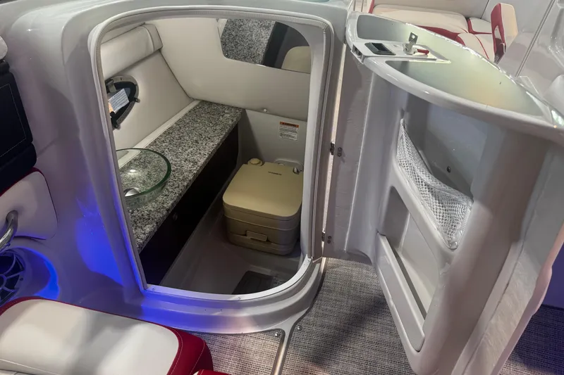 Slide: The Image of 2024 Crownline 250 XSS boat interior with compact bathroom and modern amenities. - 3