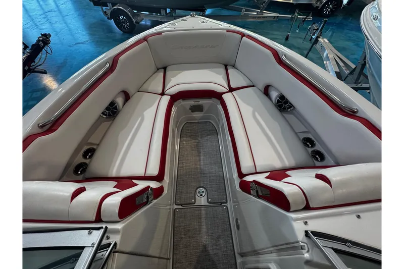 Slide: The Image of 2024 Crownline 250 XSS boat interior with red and white seating, cup holders, and speakers. - 8