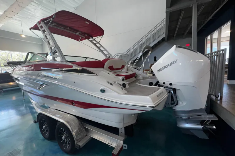 Slide: The Image of 2024 Crownline 250 XSS boat with Mercury engine, displayed indoors on a trailer. - 9