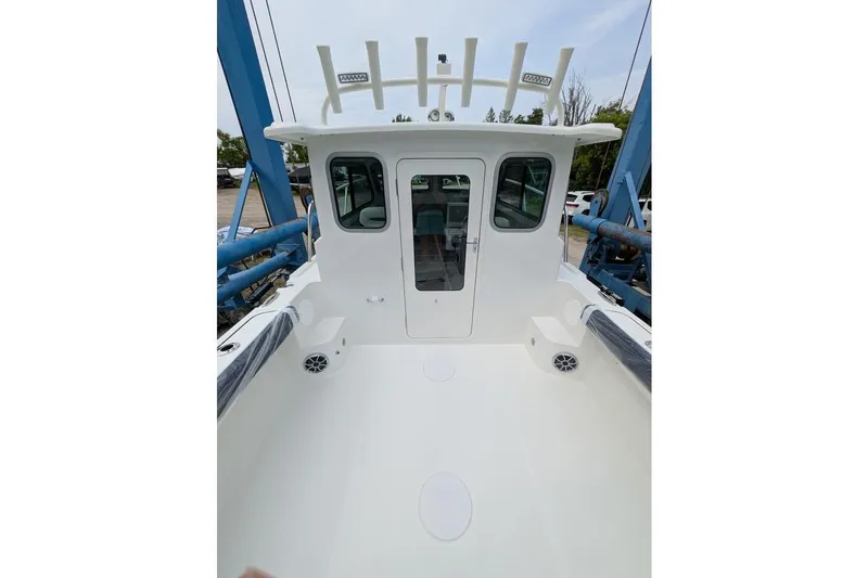 Slide: The Image of 2026 Parker 227 Explorer boat deck with cabin, white interior, and rod holders. - 14
