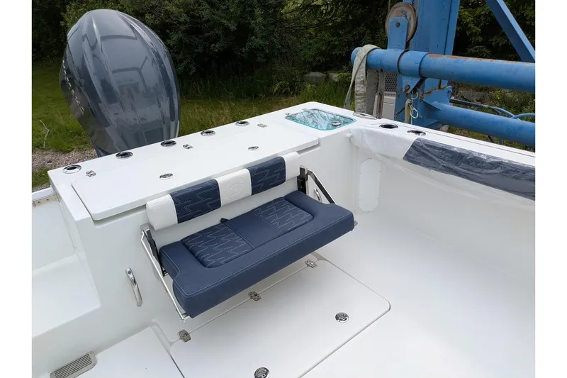 Slide: The Image of 2026 Parker 227 Explorer boat interior with blue seating and motor, docked outdoors. - 15