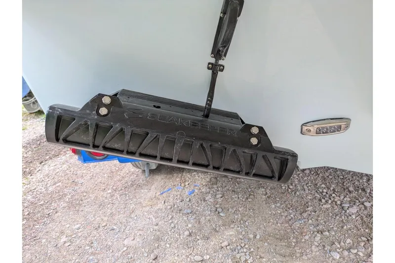 Slide: The Image of Trim tab on a 2026 Parker 227 Explorer boat, resting on gravel. - 3