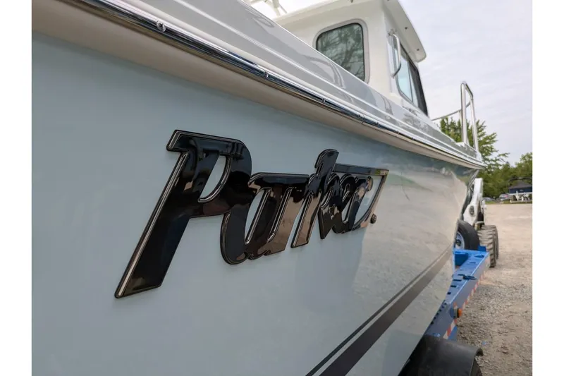 Slide: The Image of 2026 Parker 227 Explorer boat on trailer, showcasing sleek design and logo. - 5
