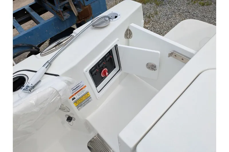 Slide: The Image of 2026 Parker 227 Explorer boat control panel with open compartment and hose attachment. - 9