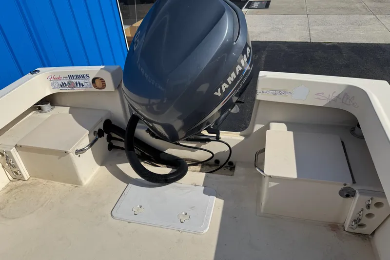 Slide: The Image of 2011 Parker 2300 Special Edition boat with Yamaha outboard motor, docked near blue building. - 5