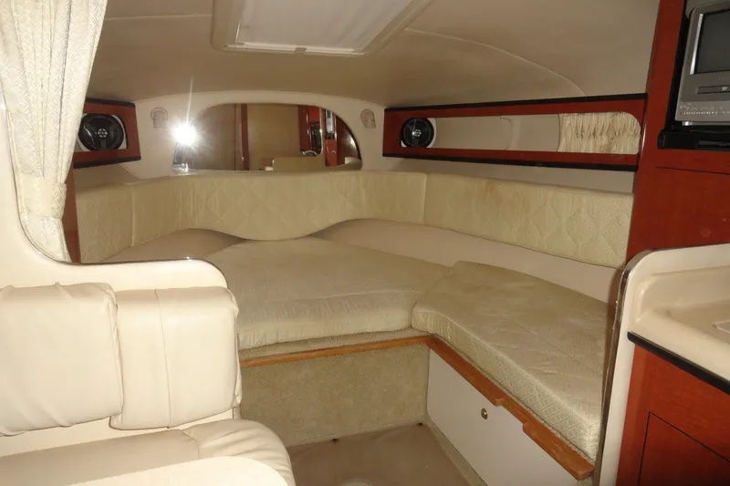 Slide: The Image of 2004 Sea Ray Sundancer 280 cabin interior with beige seating and wood accents. - 22
