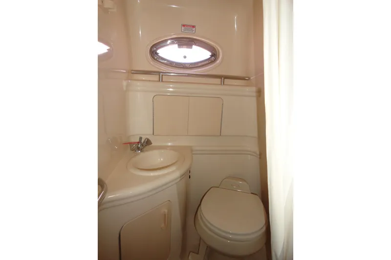 Slide: The Image of 2004 Sea Ray Sundancer 280 bathroom with sink, toilet, and porthole window. - 27