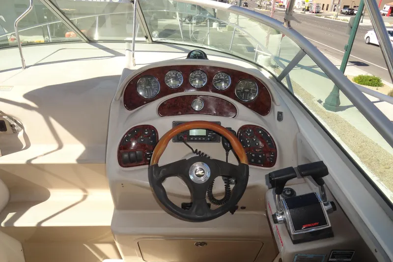 Slide: The Image of 2004 Sea Ray Sundancer 280 helm with gauges, steering wheel, and controls. - 9