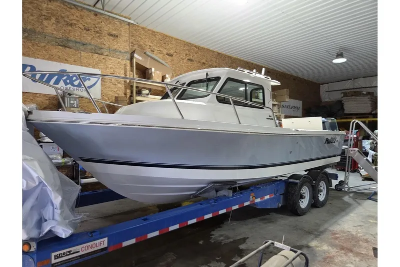 The Image of 2026 Parker 247 Explorer boat on trailer in indoor storage facility. - 0