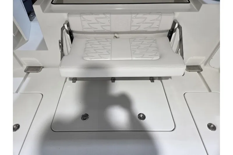 Slide: The Image of 2026 Parker 247 Explorer boat interior with white cushioned seating and storage compartments. - 13