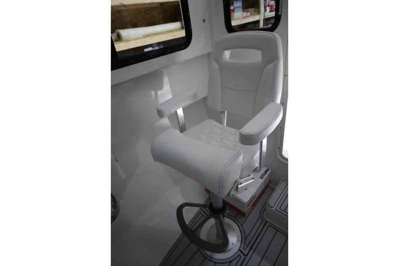 Slide: The Image of White captain's chair inside 2026 Parker 247 Explorer boat, featuring armrests and modern design. - 18