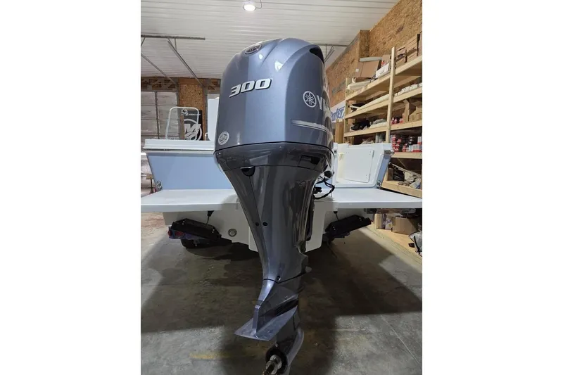 Slide: The Image of 2026 Parker 247 Explorer boat with Yamaha 300 outboard motor in a garage. - 2