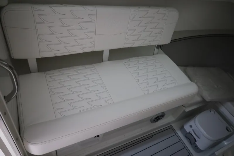 Slide: The Image of 2026 Parker 247 Explorer cabin interior with white cushioned seating and compact toilet. - 23