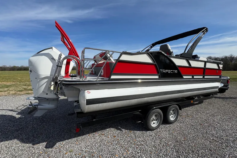 Slide: The Image of 2024 Trifecta 25ULE SS pontoon boat on trailer, featuring sleek design and powerful outboard motor. - 11