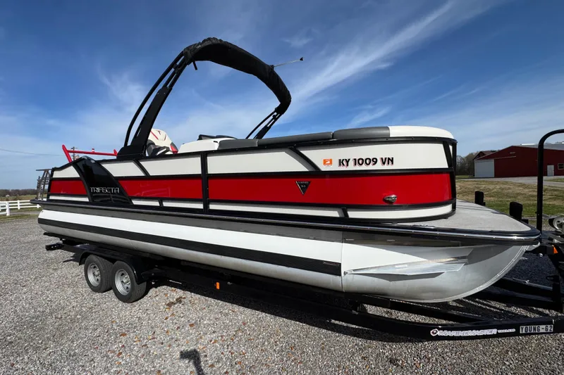 Slide: The Image of 2024 Trifecta 25ULE SS pontoon boat on trailer, red and white design. - 13
