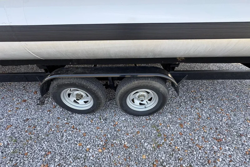 Slide: The Image of 2024 Trifecta 25ULE SS trailer wheels on gravel surface. - 31