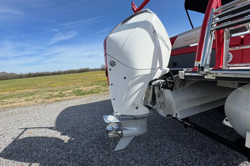 Slide: The Image of 2024 Trifecta 25ULE SS boat with Mercury outboard motor on gravel surface. - 41
