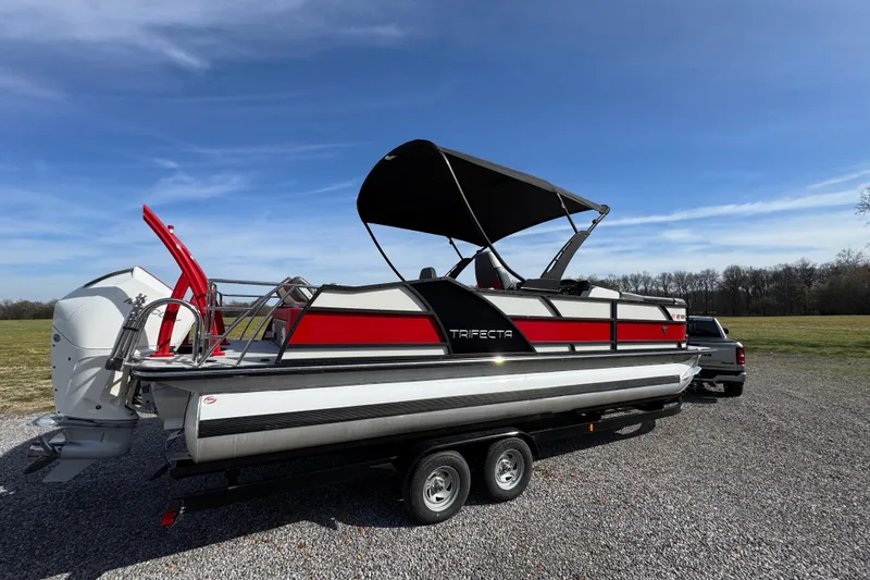 Slide: The Image of 2024 Trifecta 25ULE SS pontoon boat on trailer under clear blue sky. - 42