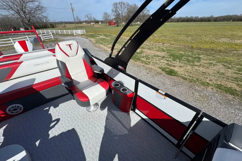 Slide: The Image of 2024 Trifecta 25ULE SS boat interior with red and white seating, cup holder, and open field view. - 49