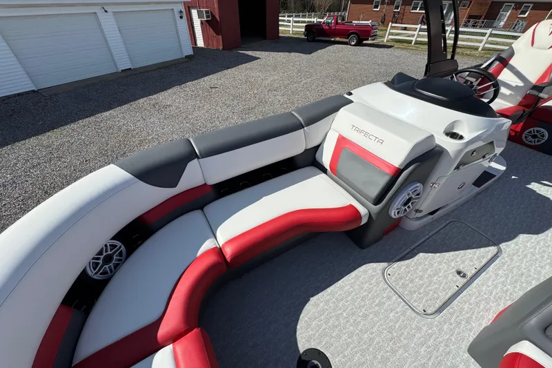 Slide: The Image of 2024 Trifecta 25ULE SS pontoon boat interior with red and gray seating. - 50