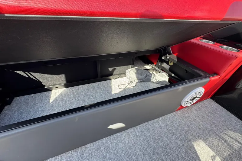 Slide: The Image of 2024 Trifecta 25ULE SS boat interior storage compartment with red seating and speaker. - 52