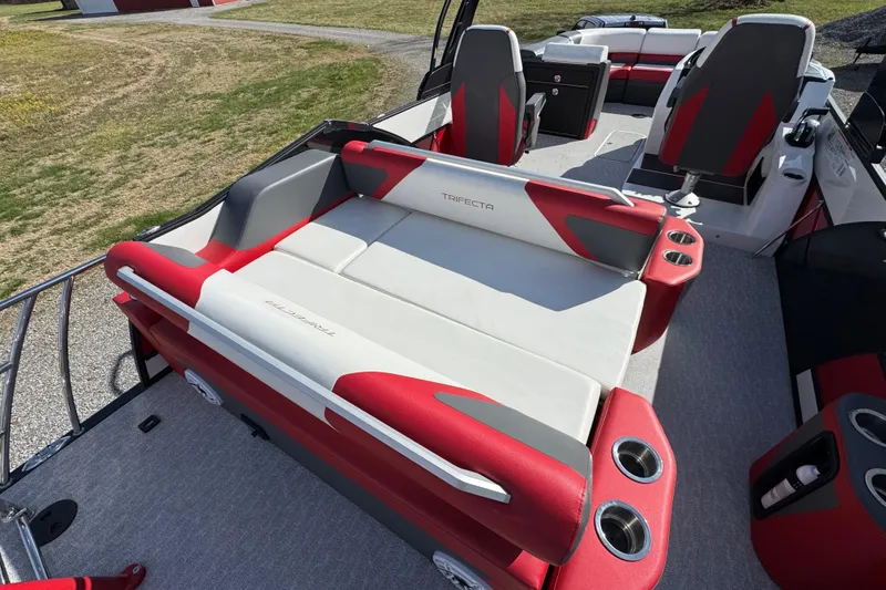 Slide: The Image of 2024 Trifecta 25ULE SS pontoon boat with red and gray seating, cup holders, and spacious deck. - 59