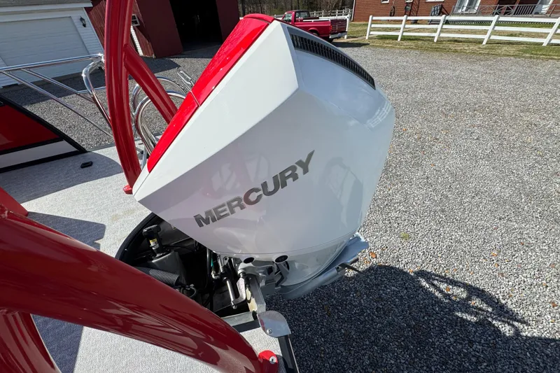 Slide: The Image of 2024 Trifecta 25ULE SS boat with Mercury outboard motor, parked on gravel driveway. - 65