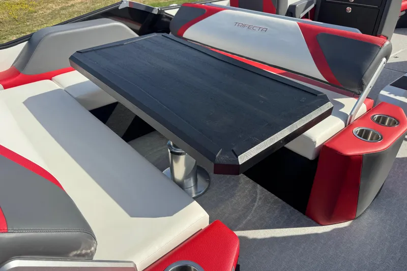 Slide: The Image of 2024 Trifecta 25ULE SS boat interior with red and gray seating and table. - 66