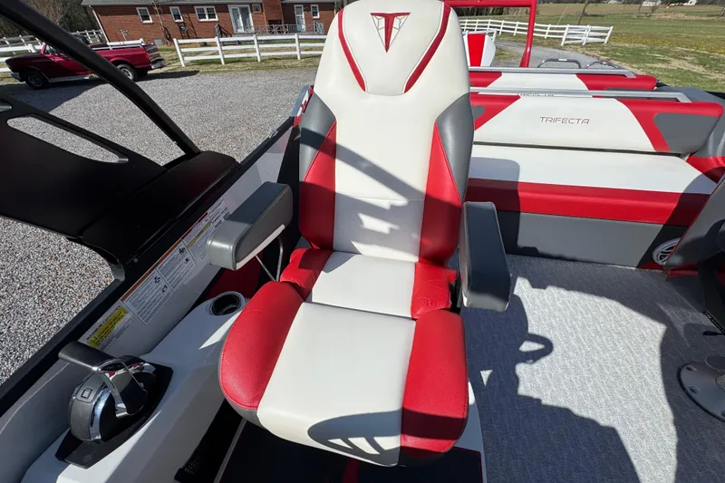 Slide: The Image of Captain's chair on 2024 Trifecta 25ULE SS pontoon boat, featuring red and white upholstery. - 76