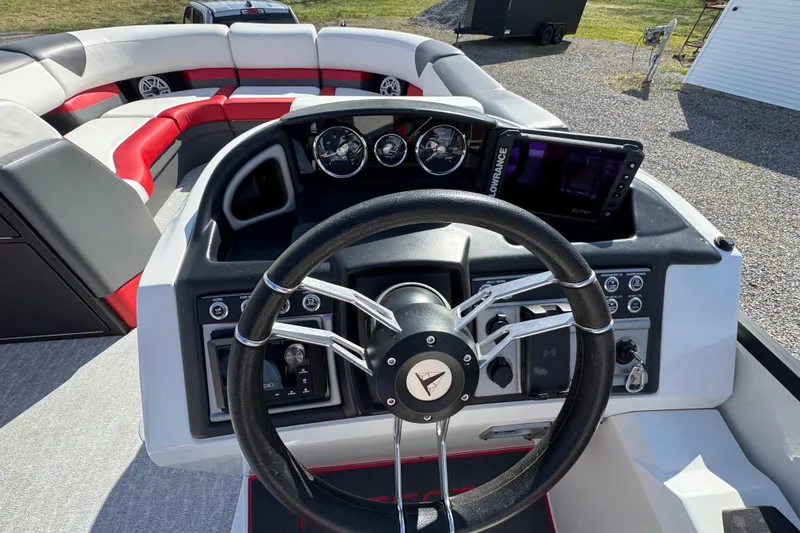 Slide: The Image of 2024 Trifecta 25ULE SS boat dashboard with steering wheel and navigation controls. - 77