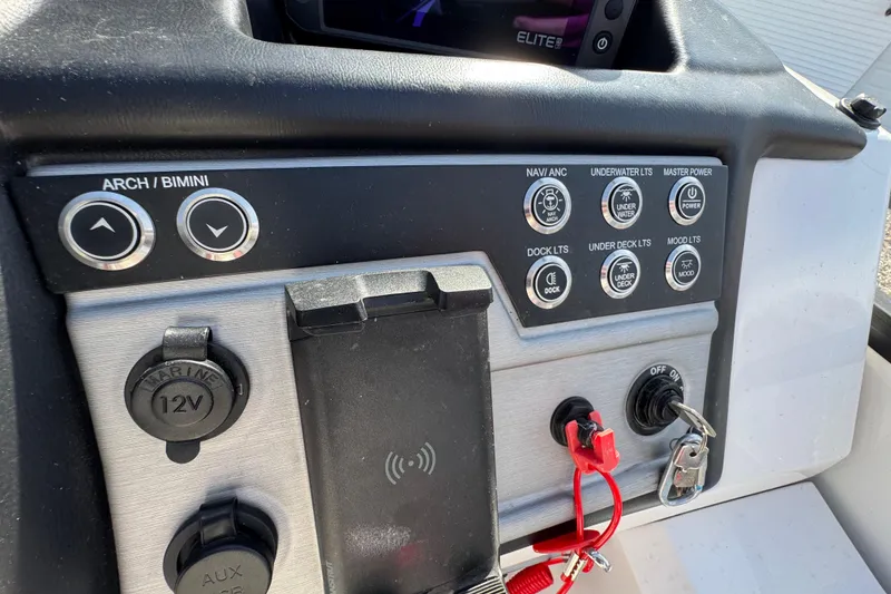 Slide: The Image of Control panel of 2024 Trifecta 25ULE SS boat with various switches and key ignition. - 79