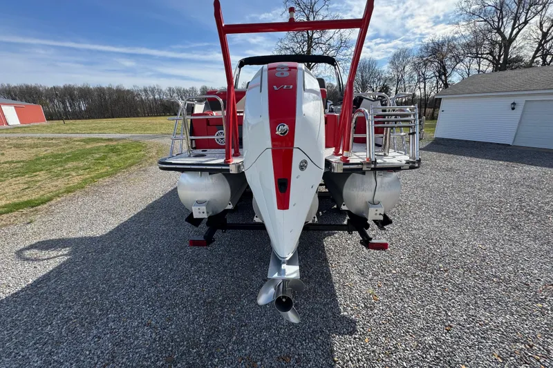 Slide: The Image of 2024 Trifecta 25ULE SS pontoon boat with powerful V8 engine, parked on gravel driveway. - 9