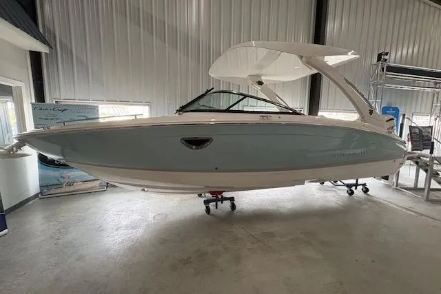 The Image of 2026 Regal LX6 boat in showroom, sleek design, white and light blue exterior. - 1