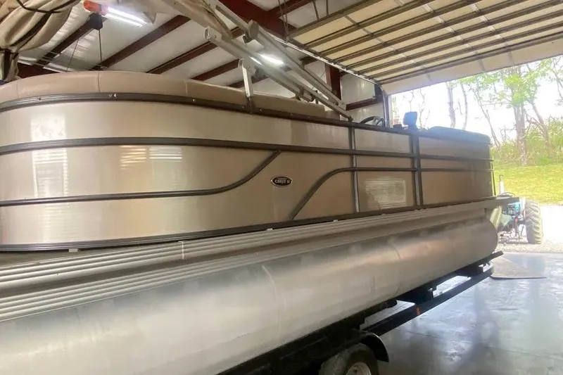 Slide: The Image of 2015 Crest 230 pontoon boat in a garage, side view. - 2