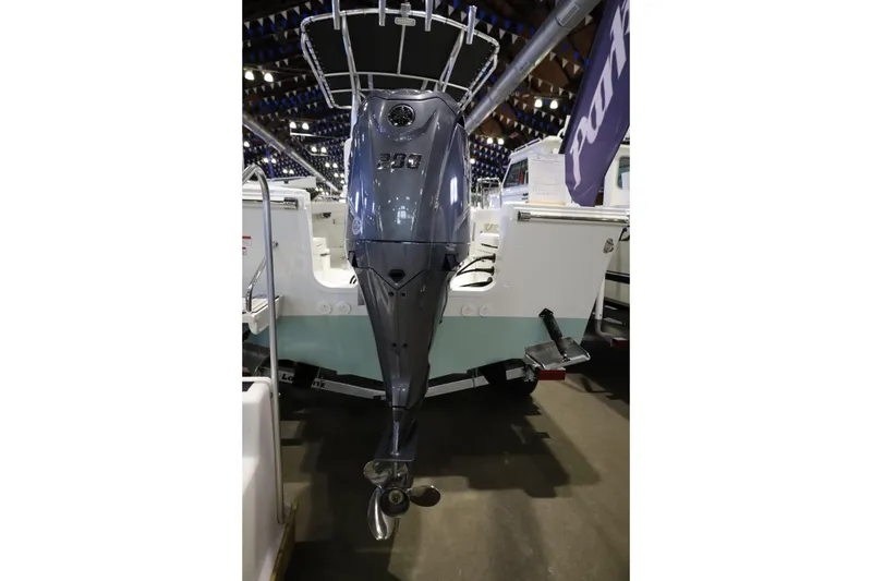 Slide: The Image of 2026 Parker 210 Coastal boat with powerful outboard motor displayed indoors. - 10
