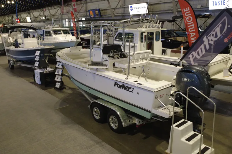 Slide: The Image of 2026 Parker 210 Coastal boat displayed indoors with Yamaha engine. - 2