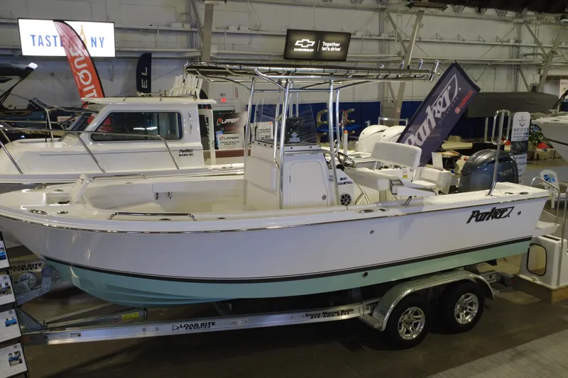Slide: The Image of 2026 Parker 210 Coastal boat displayed indoors on a trailer at a boat show. - 3