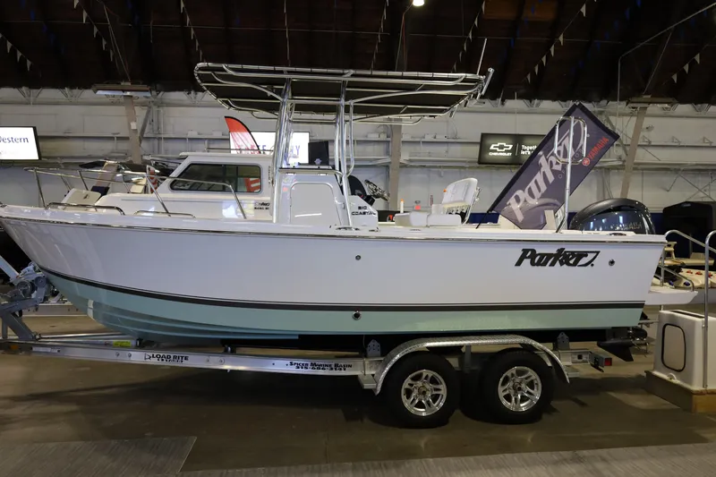 Slide: The Image of 2026 Parker 210 Coastal boat on display in an indoor showroom. - 7