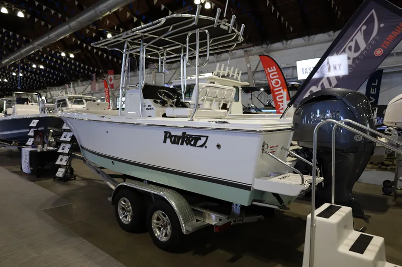 Slide: The Image of 2026 Parker 210 Coastal boat displayed indoors on a trailer at a boat show. - 8