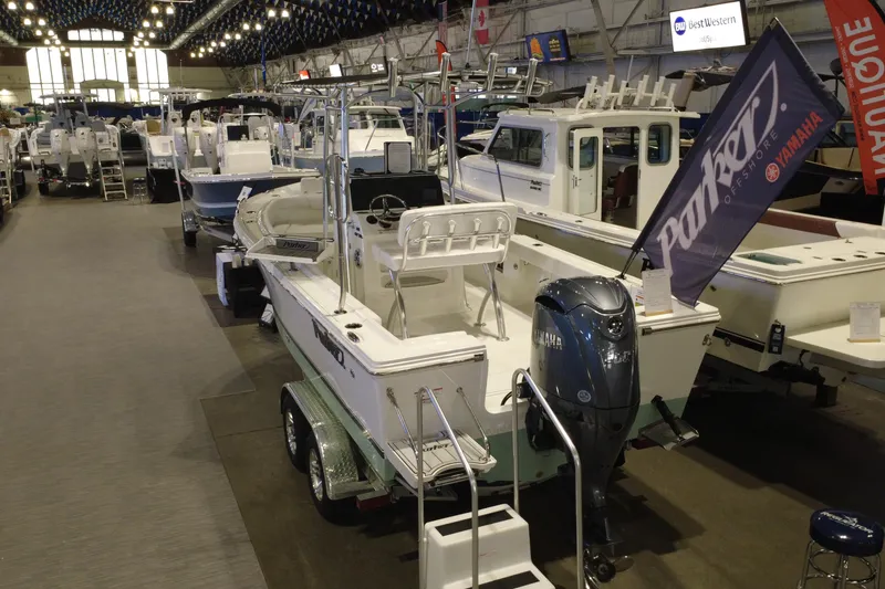 Slide: The Image of 2026 Parker 210 Coastal boat displayed at an indoor boat show with Yamaha engine. - 9