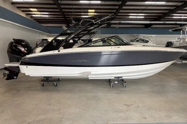 The Image of 2026 Regal LX2 boat in showroom, sleek design with black and white exterior. - 1