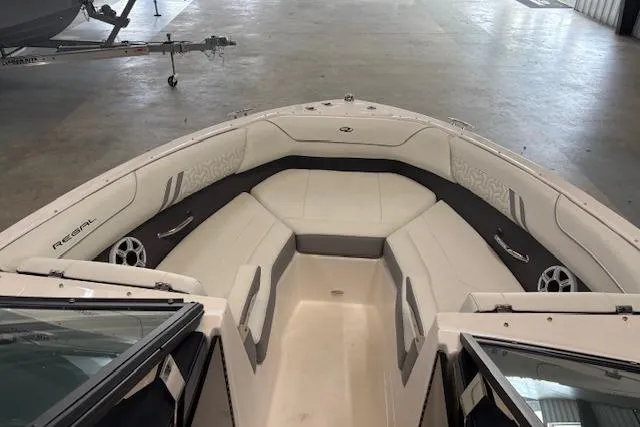 Slide: The Image of 2026 Regal LX2 boat interior with white seating and sleek design in a showroom. - 9