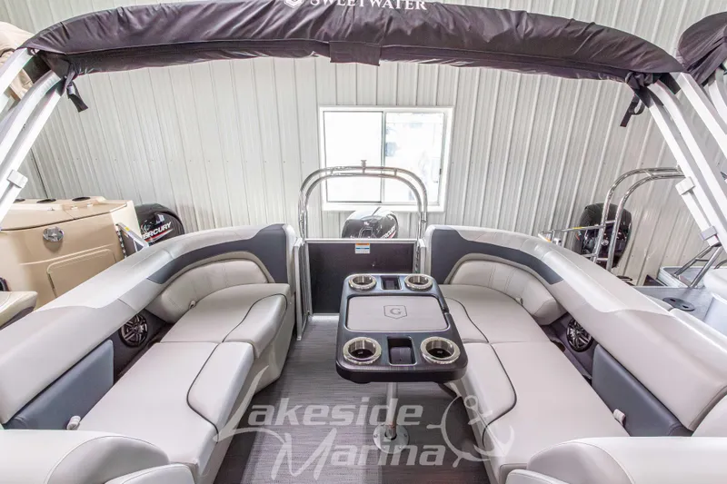 Slide: The Image of 2026 Godfrey Sweetwater 2286 SBC pontoon boat interior with plush seating and table. - 19