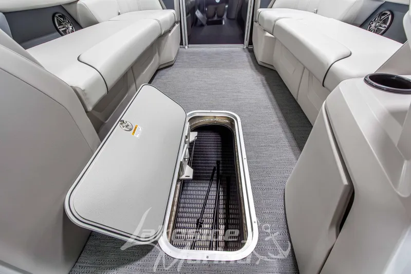 Slide: The Image of 2026 Godfrey Sweetwater 2286 SBC interior with open storage compartment, gray seating, and carpeted floor. - 9