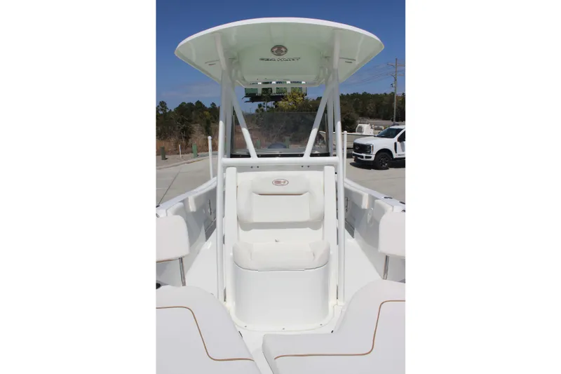 Slide: The Image of 2019 Sea Hunt Ultra 234 boat interior with seating and console, parked outdoors. - 15
