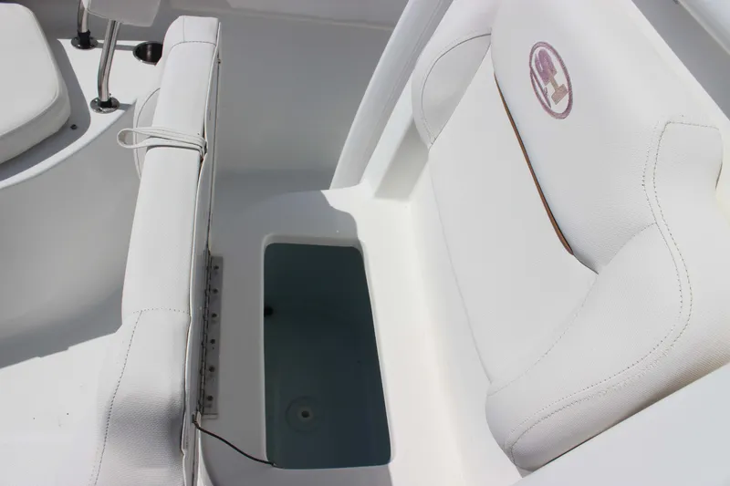 Slide: The Image of 2019 Sea Hunt Ultra 234 boat interior with white seating and storage compartment. - 16