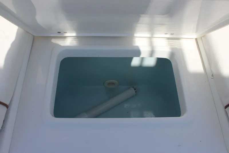 Slide: The Image of Livewell compartment on a 2019 Sea Hunt Ultra 234 boat, featuring a clean interior. - 19