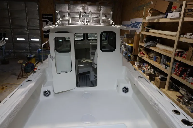 Slide: The Image of 2026 Parker 227 Explorer boat in a workshop, open cabin door, shelves with tools. - 3