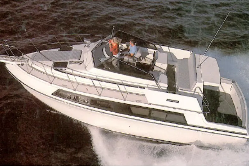 The Image of 1996 Carver 330 Mariner cruising on open water, showcasing sleek design and spacious deck. - 0